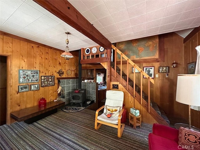 41132 Oak Dr, Forest Falls, CA 92339 - living area featuring wood walls, carpet flooring, a wood stove, stairs, and beamed ceiling