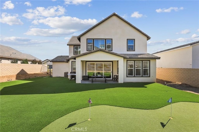 28709 Wildflower, Castaic, CA 91384 - rear view of house with an area to practice putting, a fenced backyard, and stucco siding