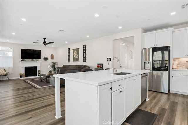 28709 Wildflower, Castaic, CA 91384 - kitchen with appliances with stainless steel finishes, a fireplace with raised hearth, wood finished floors, light countertops, and recessed lighting