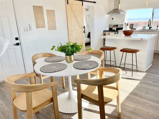 3191 Pearl Springs Ave Unit 29, Palms, CA 92277 - dining area with a barn door and light wood-type flooring