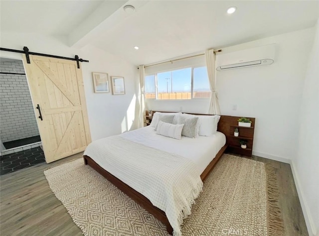 3191 Pearl Springs Ave Unit 29, Palms, CA 92277 - bedroom featuring a wall mounted AC, a barn door, wood finished floors, and recessed lighting