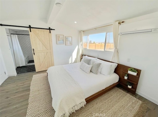 3191 Pearl Springs Ave Unit 29, Palms, CA 92277 - bedroom with a wall mounted AC, a barn door, and wood finished floors