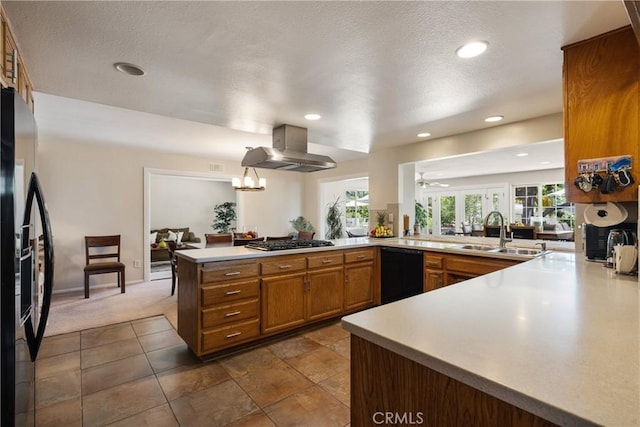 8652 Surrey Ln, Rancho Cucamonga, CA 91701 - kitchen with ventilation hood, black appliances, a peninsula, brown cabinetry, and dark colored carpet