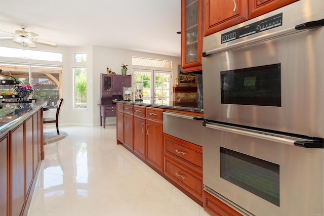 4883 Bradshaw Ct, San Diego, CA 92130 - kitchen featuring double oven, a warming drawer, glass insert cabinets, a ceiling fan, and light tile patterned floors
