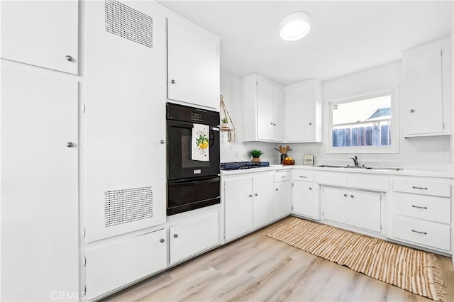 16271 Fairway Ln, Huntington Beach, CA 92649 - kitchen featuring a warming drawer, black oven, gas stovetop, light countertops, and white cabinets