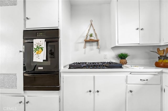 16271 Fairway Ln, Huntington Beach, CA 92649 - kitchen with a warming drawer, black oven, white cabinetry, light countertops, and stainless steel gas stovetop