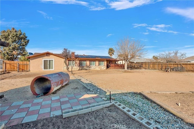 19055 Seaforth St, Hesperia, CA 92345 - rear view of house with roof mounted solar panels and a fenced backyard