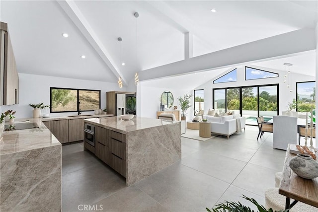 29951 Morongo Pl, Laguna Niguel, CA 92677 - kitchen with modern cabinets, light stone countertops, beamed ceiling, stainless steel oven, and high vaulted ceiling
