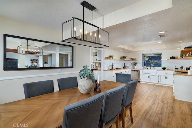 40630 Calle Torcida, Temecula, CA 92591 - dining area with a chandelier, a textured ceiling, light wood finished floors, and a tray ceiling