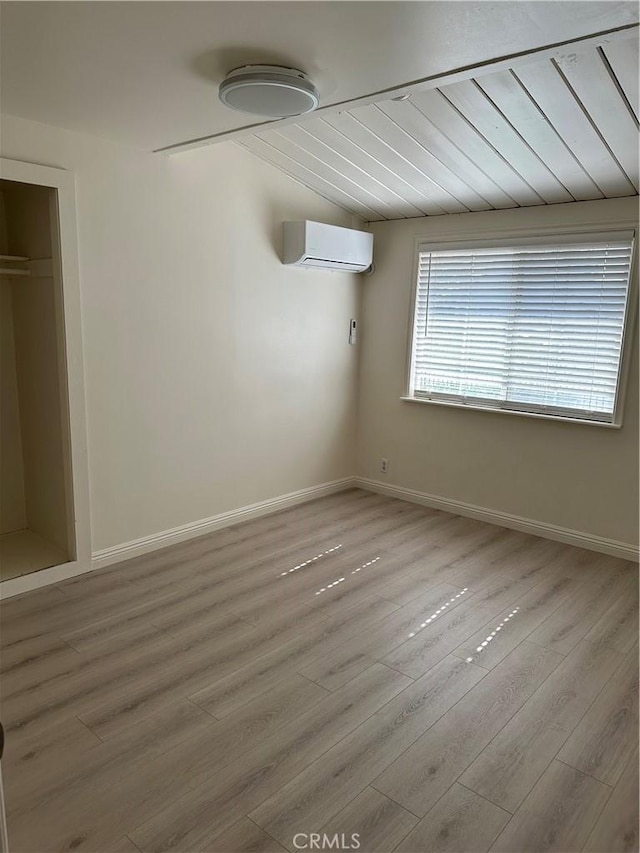 1322 S Walnut Ave, West Covina, CA 91790 - unfurnished bedroom with an AC wall unit, wood finished floors, and vaulted ceiling