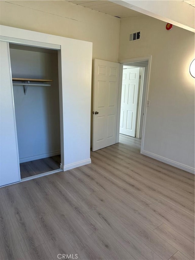 1322 S Walnut Ave, West Covina, CA 91790 - unfurnished bedroom featuring wood finished floors, a closet, and lofted ceiling