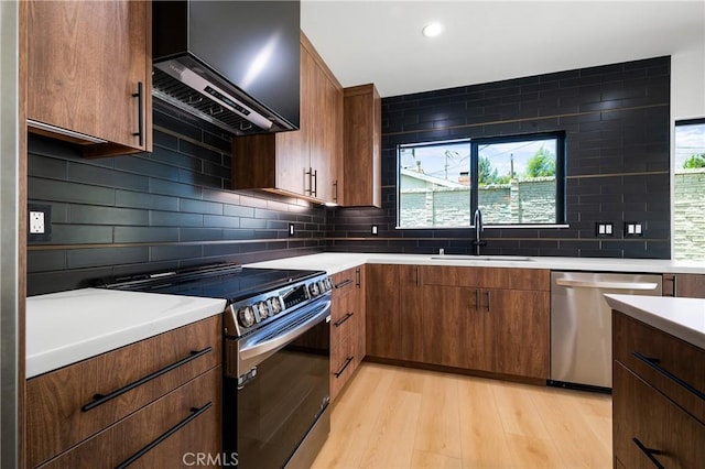 16701 Kalisher, Granada Hills, CA 91344 - kitchen with appliances with stainless steel finishes, wall chimney range hood, light countertops, light wood-type flooring, and tasteful backsplash