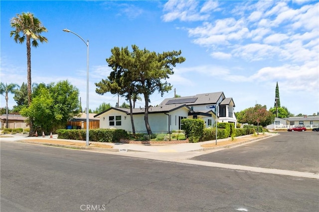 16701 Kalisher, Granada Hills, CA 91344 - view of front of house featuring roof mounted solar panels, stucco siding, and a residential view