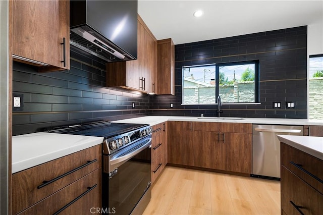 16701 Kalisher, Granada Hills, CA 91344 - kitchen with stainless steel appliances, wall chimney exhaust hood, light countertops, light wood-style floors, and tasteful backsplash