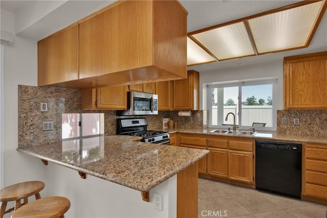 1850 Coolidge St, Corona, CA 92879 - kitchen featuring appliances with stainless steel finishes, a peninsula, light stone countertops, decorative backsplash, and a breakfast bar