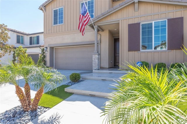 2227 Melogold Way, Corona, CA 92883 - view of front of property with concrete driveway, an attached garage, board and batten siding, and stucco siding