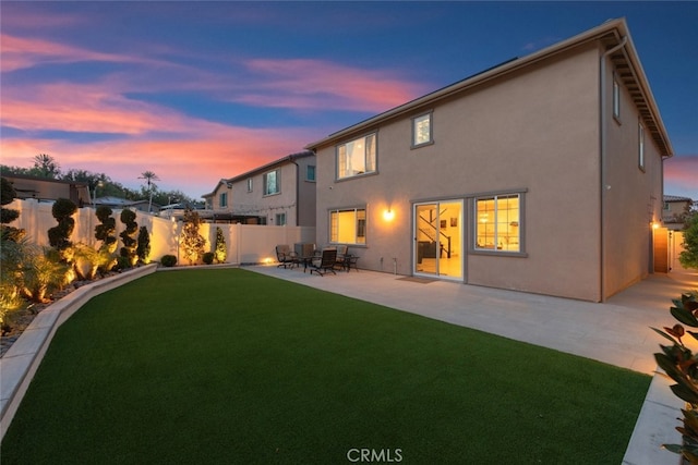 2227 Melogold Way, Corona, CA 92883 - back of house at dusk with a fenced backyard, a patio, and stucco siding
