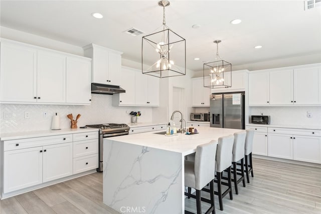 2227 Melogold Way, Corona, CA 92883 - kitchen featuring stainless steel appliances, under cabinet range hood, a chandelier, recessed lighting, and white cabinets