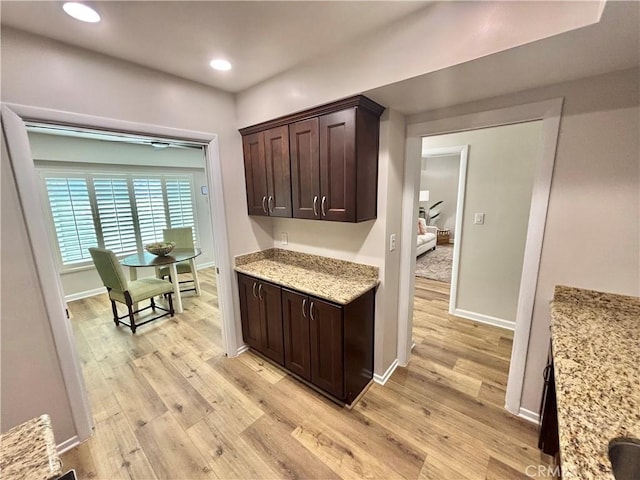 1521 S Pomona Ave Unit A23, Fullerton, CA 92832 - kitchen with dark brown cabinets, light wood-style flooring, recessed lighting, and light stone countertops