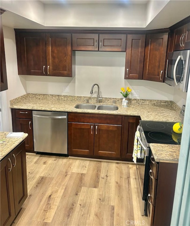 1521 S Pomona Ave Unit A23, Fullerton, CA 92832 - kitchen with stainless steel appliances, light wood finished floors, dark brown cabinetry, and light stone counters