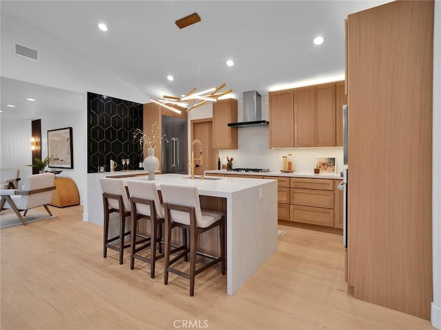 24100 Philiprimm St, Woodland Hills, CA 91367 - kitchen with wall chimney exhaust hood, gas stovetop, light countertops, light wood finished floors, and recessed lighting
