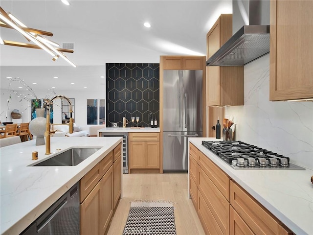 24100 Philiprimm St, Woodland Hills, CA 91367 - kitchen featuring appliances with stainless steel finishes, wall chimney exhaust hood, backsplash, light wood-type flooring, and beverage cooler