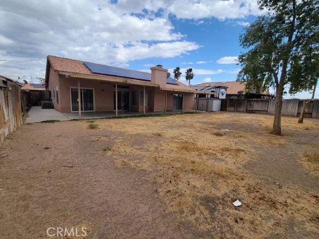 441 River Vly, Blythe, CA 92225 - back of property featuring roof mounted solar panels, a fenced backyard, a patio, a storage unit, and stucco siding