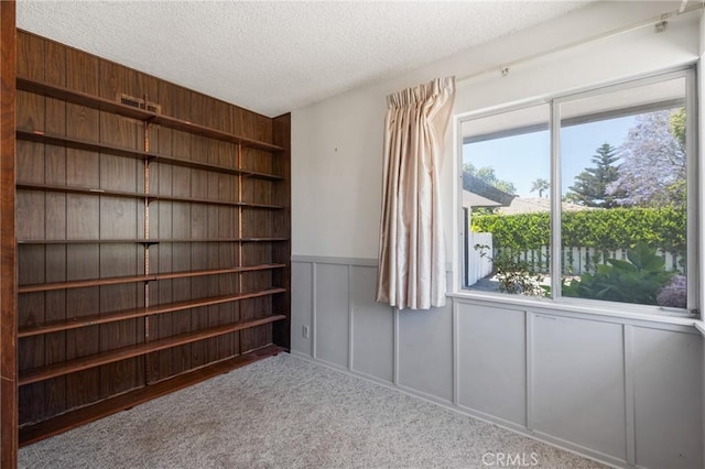 8 Coveview Dr, Rancho Palos Verdes, CA 90275 - carpeted empty room featuring a textured ceiling, a decorative wall, and wainscoting