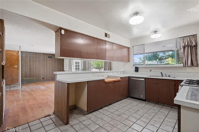 8 Coveview Dr, Rancho Palos Verdes, CA 90275 - kitchen with stainless steel dishwasher, light countertops, wooden walls, and a peninsula