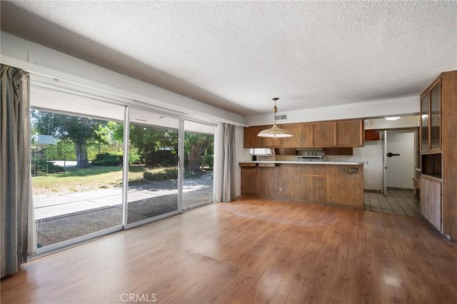 8 Coveview Dr, Rancho Palos Verdes, CA 90275 - kitchen featuring brown cabinetry, a peninsula, light wood-type flooring, a textured ceiling, and light countertops