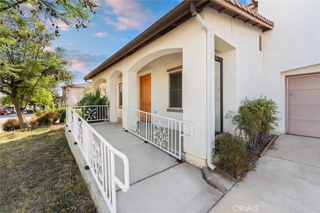 27132 Golden Field Ct, Moreno Valley, CA 92555 - view of exterior entry featuring stucco siding, a porch, and a garage
