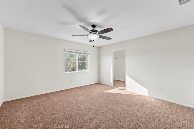 27132 Golden Field Ct, Moreno Valley, CA 92555 - unfurnished bedroom with light colored carpet, ceiling fan, and a walk in closet