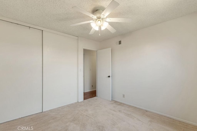 207 N Pasadena Ave, Azusa, CA 91702 - unfurnished bedroom with a textured ceiling, light colored carpet, a closet, and ceiling fan