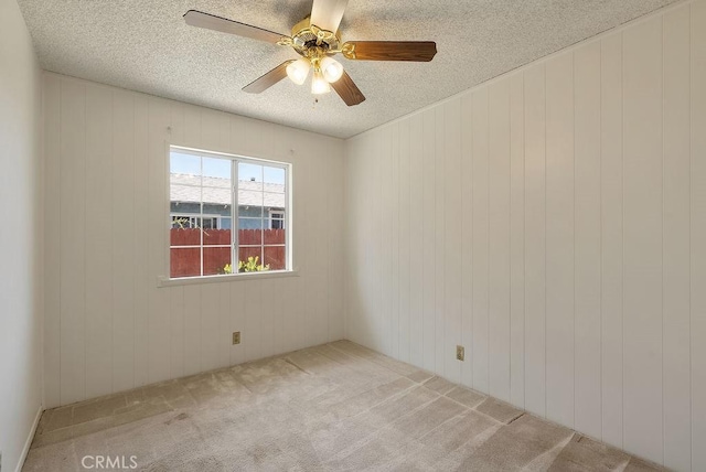 207 N Pasadena Ave, Azusa, CA 91702 - empty room with carpet floors, a ceiling fan, a textured ceiling, and wood walls