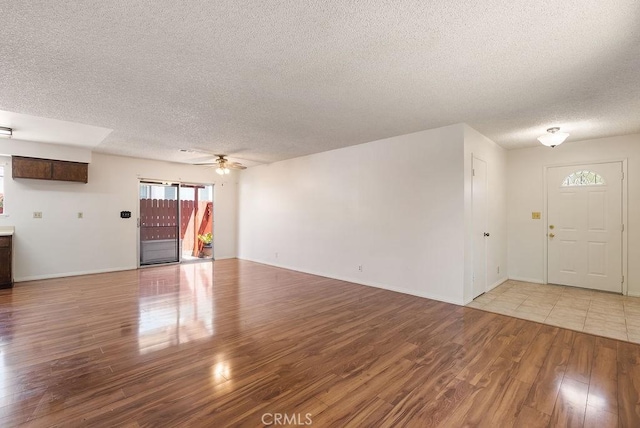 207 N Pasadena Ave, Azusa, CA 91702 - unfurnished living room featuring a textured ceiling, light wood-style flooring, and ceiling fan