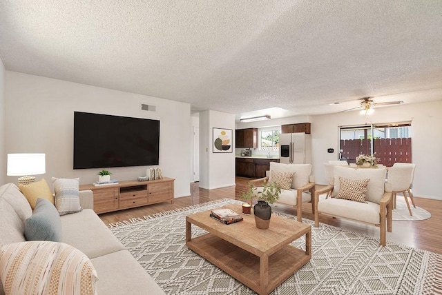 207 N Pasadena Ave, Azusa, CA 91702 - living area with light wood-type flooring, a textured ceiling, and ceiling fan