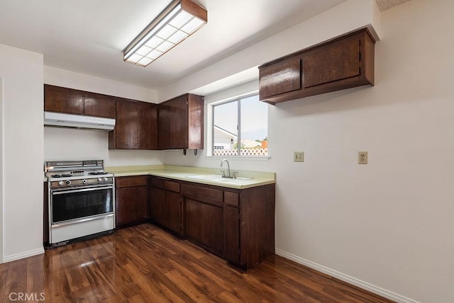 207 N Pasadena Ave, Azusa, CA 91702 - kitchen featuring white gas stove, under cabinet range hood, dark brown cabinetry, light countertops, and dark wood-type flooring