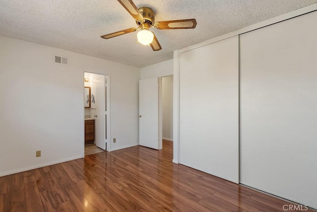 207 N Pasadena Ave, Azusa, CA 91702 - unfurnished bedroom with a textured ceiling, wood finished floors, a closet, ceiling fan, and connected bathroom