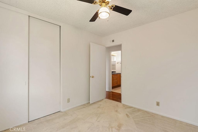 207 N Pasadena Ave, Azusa, CA 91702 - unfurnished bedroom with a textured ceiling, light colored carpet, a closet, and ceiling fan