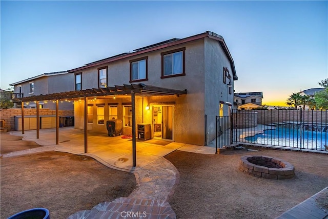 2322 Carolyn Dr, Palmdale, CA 93551 - back of property at dusk with a fire pit, a pergola, stucco siding, and a patio area