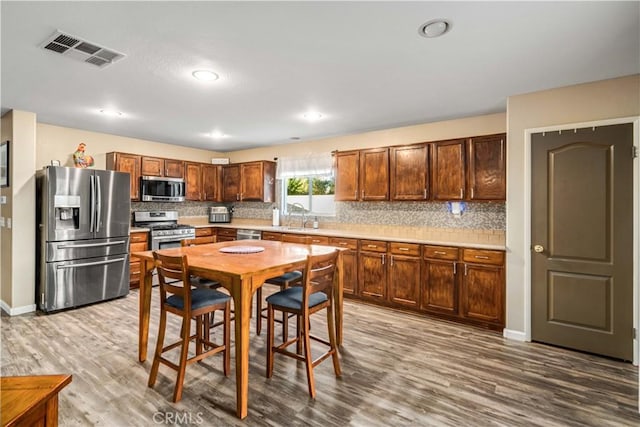 2322 Carolyn Dr, Palmdale, CA 93551 - kitchen with appliances with stainless steel finishes, wood finished floors, decorative backsplash, light countertops, and recessed lighting