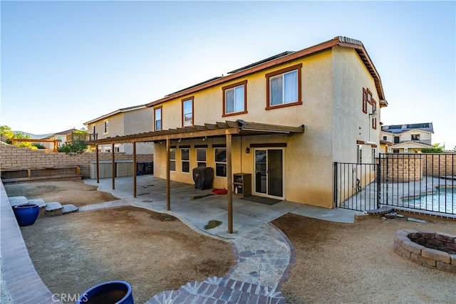 2322 Carolyn Dr, Palmdale, CA 93551 - back of property featuring a fire pit, stucco siding, a fenced backyard, and a patio area