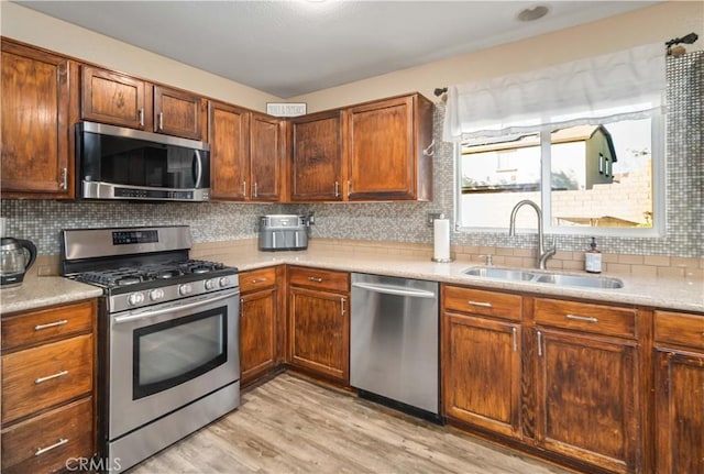 2322 Carolyn Dr, Palmdale, CA 93551 - kitchen with appliances with stainless steel finishes, light wood-type flooring, light countertops, and tasteful backsplash