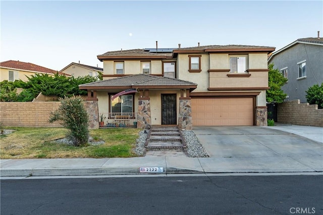 2322 Carolyn Dr, Palmdale, CA 93551 - view of front of house featuring stucco siding, solar panels, a porch, driveway, and a garage