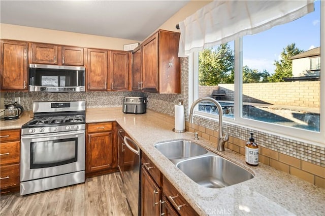 2322 Carolyn Dr, Palmdale, CA 93551 - kitchen with appliances with stainless steel finishes, light wood finished floors, decorative backsplash, and light stone countertops