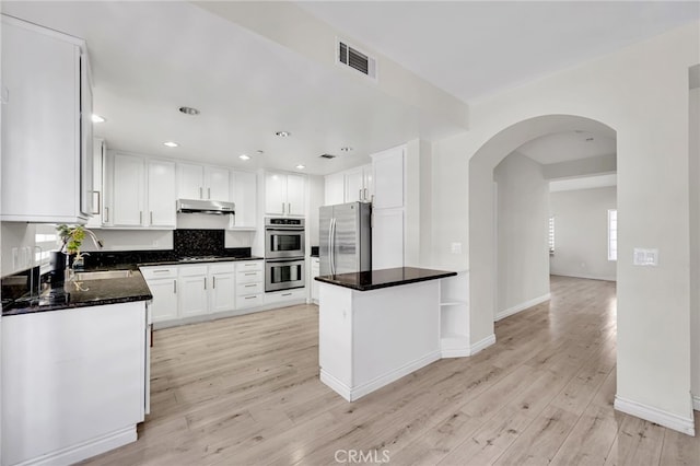 3470 E Temple Way, West Covina, CA 91791 - kitchen featuring stainless steel appliances, under cabinet range hood, arched walkways, white cabinetry, and light wood-style floors