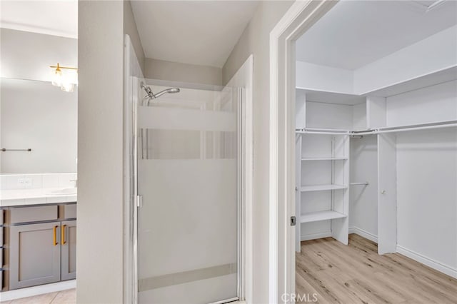 3470 E Temple Way, West Covina, CA 91791 - full bathroom featuring a walk in closet, a shower stall, vanity, and wood finished floors