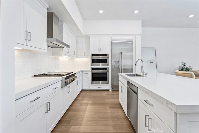 1505 Rivington, Irvine, CA 92612 - kitchen with wall chimney range hood, stainless steel appliances, light countertops, white cabinets, and recessed lighting