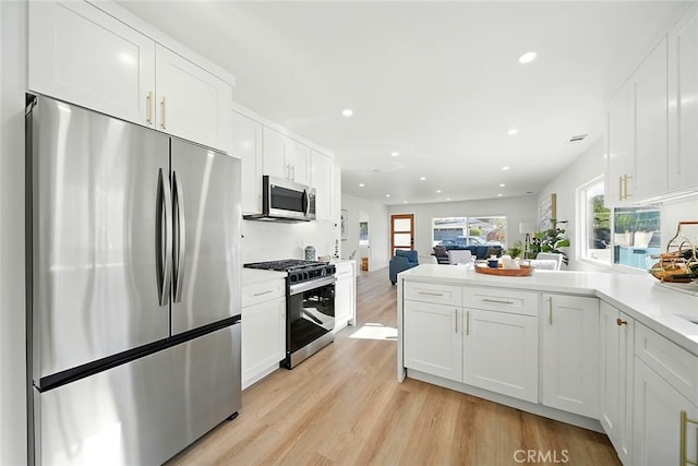 482 Mountain View St, Altadena, CA 91001 - kitchen with appliances with stainless steel finishes, recessed lighting, white cabinets, a peninsula, and light wood-style floors