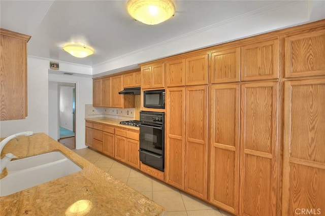 902 W Lucille Ave, West Covina, CA 91790 - kitchen with black appliances, light tile patterned floors, a warming drawer, under cabinet range hood, and brown cabinetry